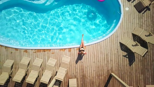 Top view fit girl enjoy swimming pool sunny summer sunrise drone footage