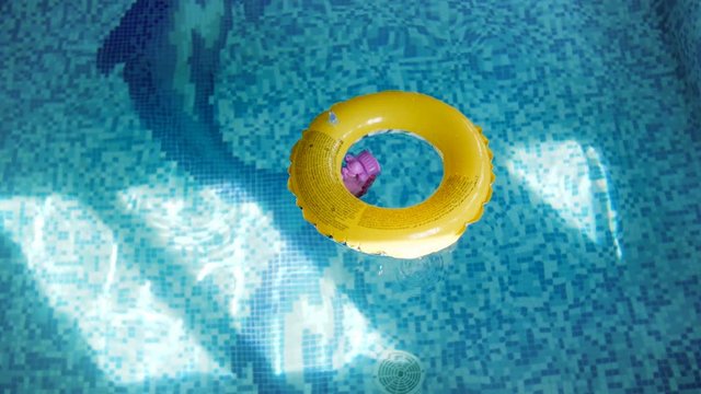 4k footage of inflatable ring for children on swimming pool water surface