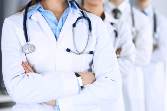 Group of modern doctors standing as a team with arms crossed in hospital office. Physicians ready to examine and help patients. Medical help, insurance in health care, best desease treatment and