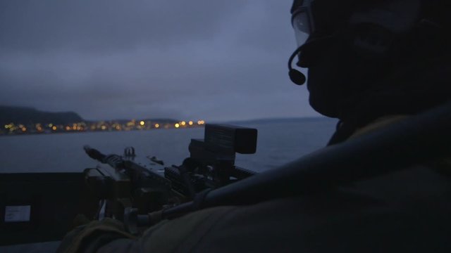 Close up of front gunner on high speed army attack boat in southern Norway