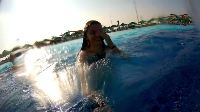 Happy caucasian girl jumping in swimming pool on holidays. High quality FullHD footage