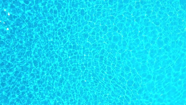 Blue water in the swimming pool with light reflections. Aerial footage