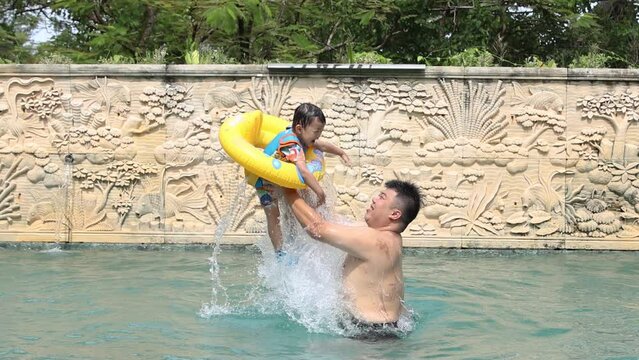 Happy Asian kids with father playing on swimming pool footage in slow motion