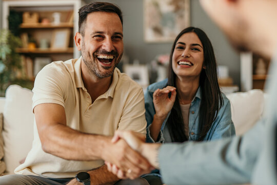 The young happy couple and an agent in a new property, or a professional psychologist advising spouses helping them restore marriage, and handsaking