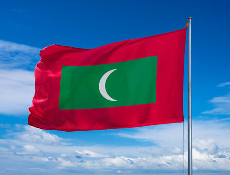 Maldives flag waving in the wind against a blue sky background