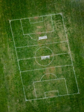 Aerial view of a vibrant football court surrounded by lush green grass and urban landscape, Basic City, Virginia, United States.