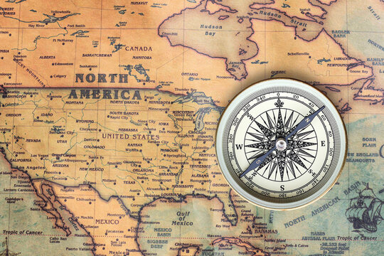 Classic round compass on background of old vintage map