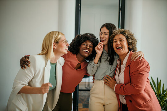 The excited business team gives a high five to celebrate corporate success. 