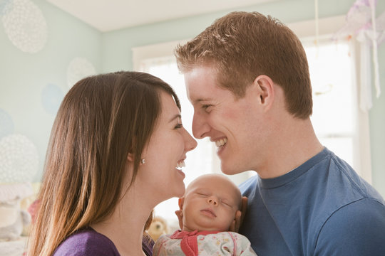 Caucasian mother and father holding baby girl