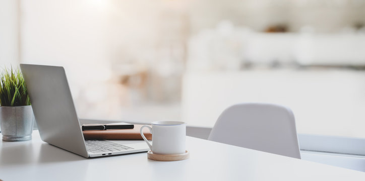 Modern workplace with laptop computer, coffee cup and office supplies