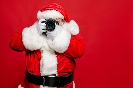 Portrait of focused elderly santa claus hipster take photo of his christmas time voyage abroad wear stylish costume belt gloves isolated over red background