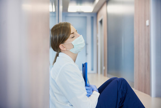 Exhausted doctor on hospital corridor