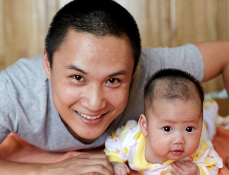 Closeup of newborn Asian baby and father