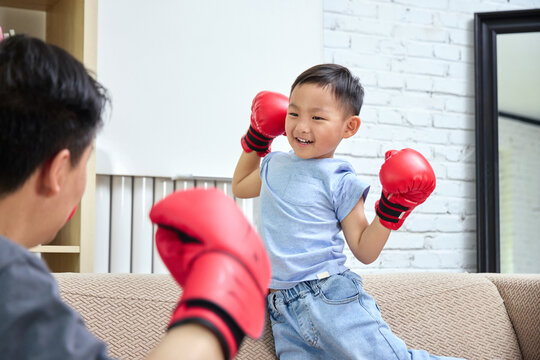 Father and son wearing boxing gloves