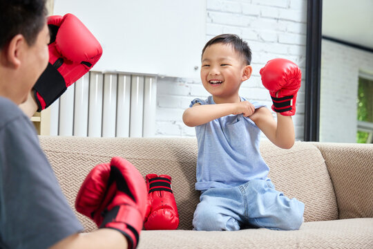 Father and son wearing boxing gloves