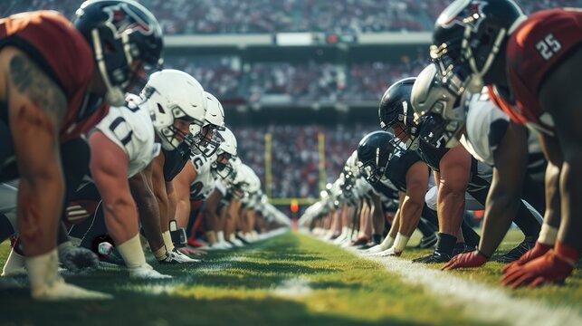 American football teams face off at the line of scrimmage, players in full gear with intense focus on stadium. Ready to start the game