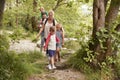 Family Hiking Along Path By River In UK Lake District