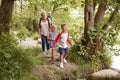 Family Hiking Along Path By River In UK Lake District