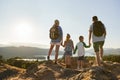 Rear View Of Family Standing At Top Of Hill On Hike Through Countryside In Lake District UK