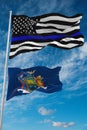 thin blue line flag of US with smaller flag of New York state, Usa at cloudy sky background. United states of America police flag