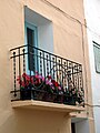 Detalle de balcón tradicional con flores en una casa de Torrebaja (Valencia), calle del Rosario.