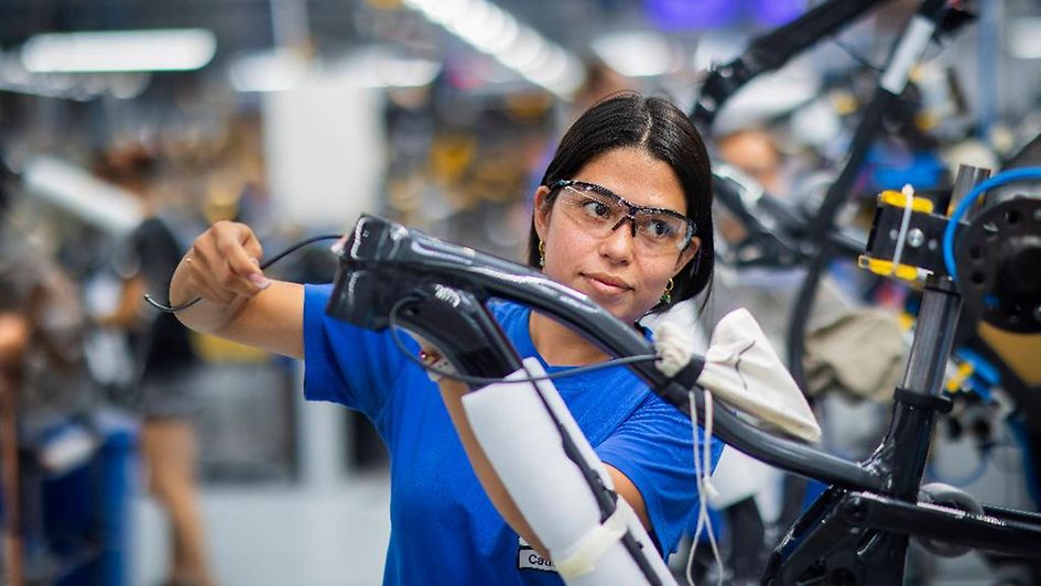 Une ouvrière qualifiée assemble une bicyclette.