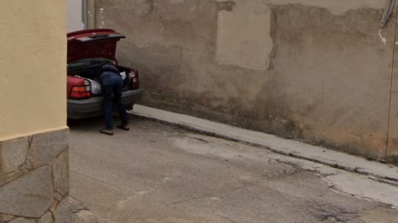 A picture, which Spanish police used as part of a missing person investigation, shows a man placing what appears to be a bag with a body in a car's trunk, in Tajueco, Spain, dated October 2024 (Courtesy Google Street View/Handout via REUTERS)