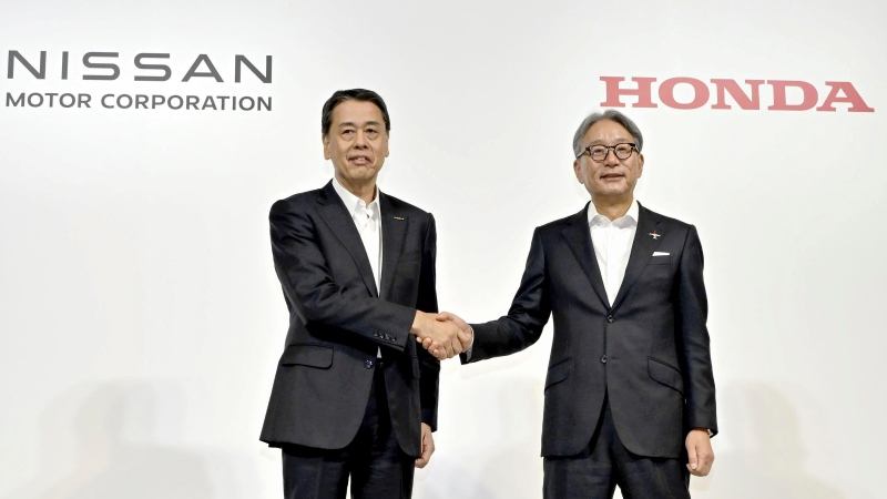 Nissan chief executive Makoto Uchida, left, and Honda chief executive Toshihiro Mibe shake hands during a joint news conference in Tokyo, Aug. 1, 2024. (Kyodo News via AP)