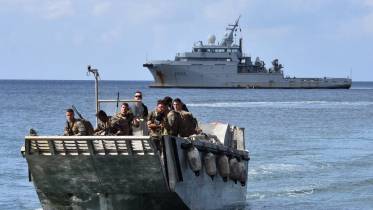 Una barcazas de desembarco lleva a tierra a infantes de marina del 33 RIMa, en el fondo el Dumont d