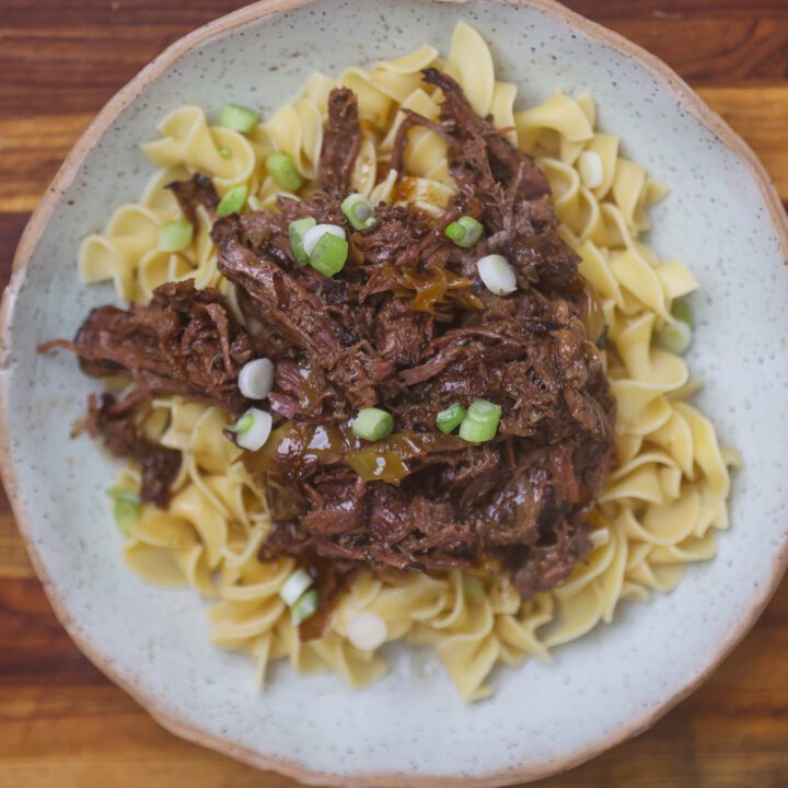 mississippi pot roast shredded on top of egg noodles