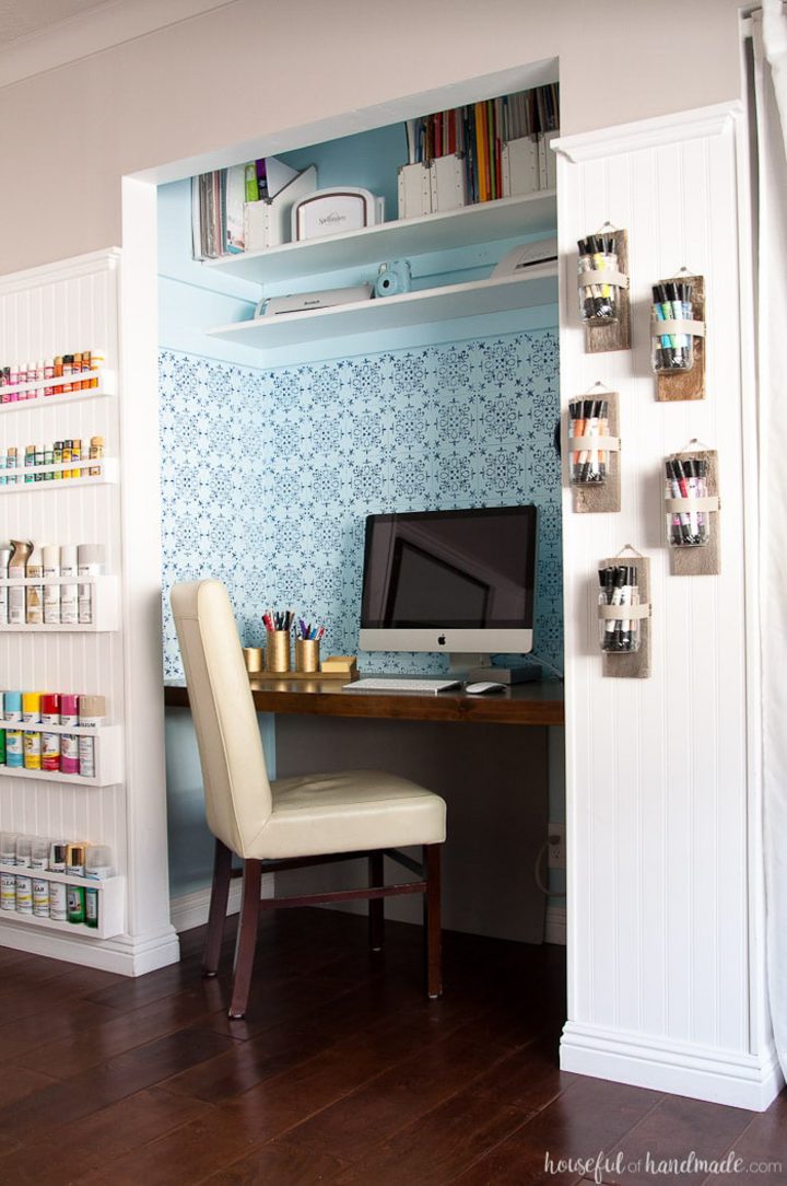 Closet home office with a blue stenciled pattern on the wall behind the desk