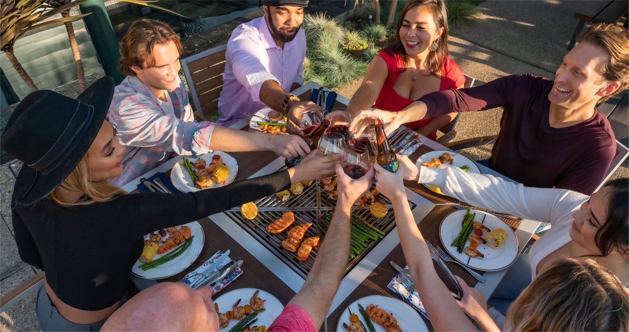 People gathered around a modern outdoor backyard grill table