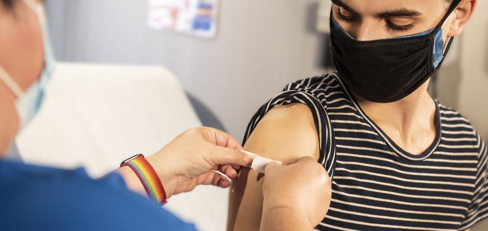 An adolescent boy is vaccinated against COVID-19