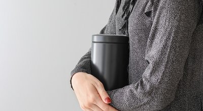 Woman,With,Mortuary,Urn,On,Light,Background