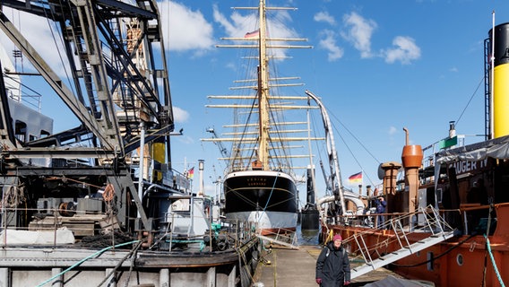 Das Museumssegelschiff "Peking" liegt am Hafenmuseum zwischen einem historischen Schwimmkran und einem Saugbagger. © picture alliance/dpa Foto: Markus Scholz