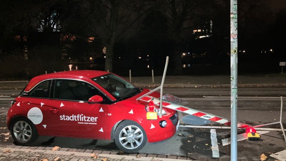 Eine Barrikade für eine Straßensperrung liegt auf der Motorhaube eines Pkw. © NDR Foto: Josy Wübben