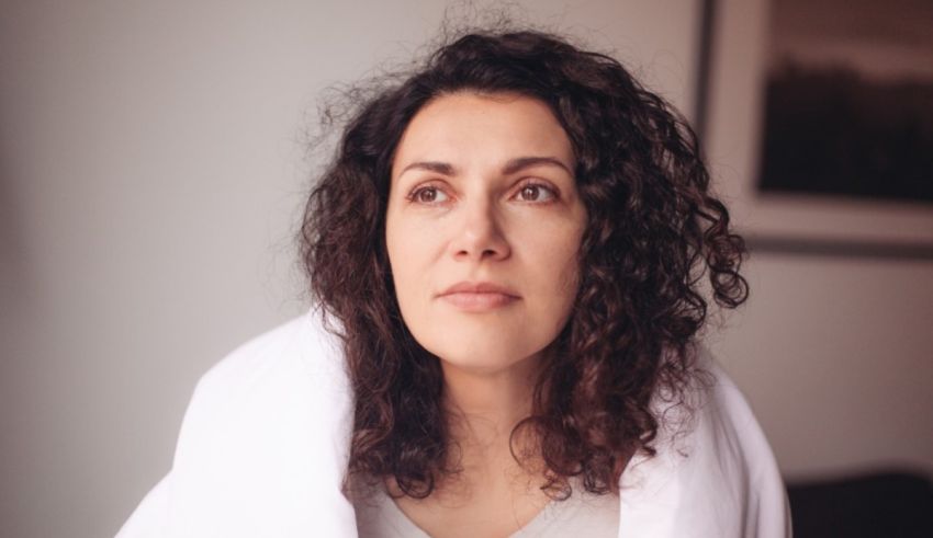 A woman with curly hair wrapped in a towel.