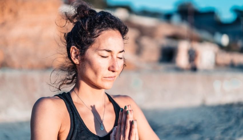 A woman is meditating on the beach.