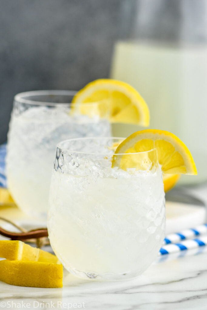 two glasses of vodka lemonade with ice and lemon slices