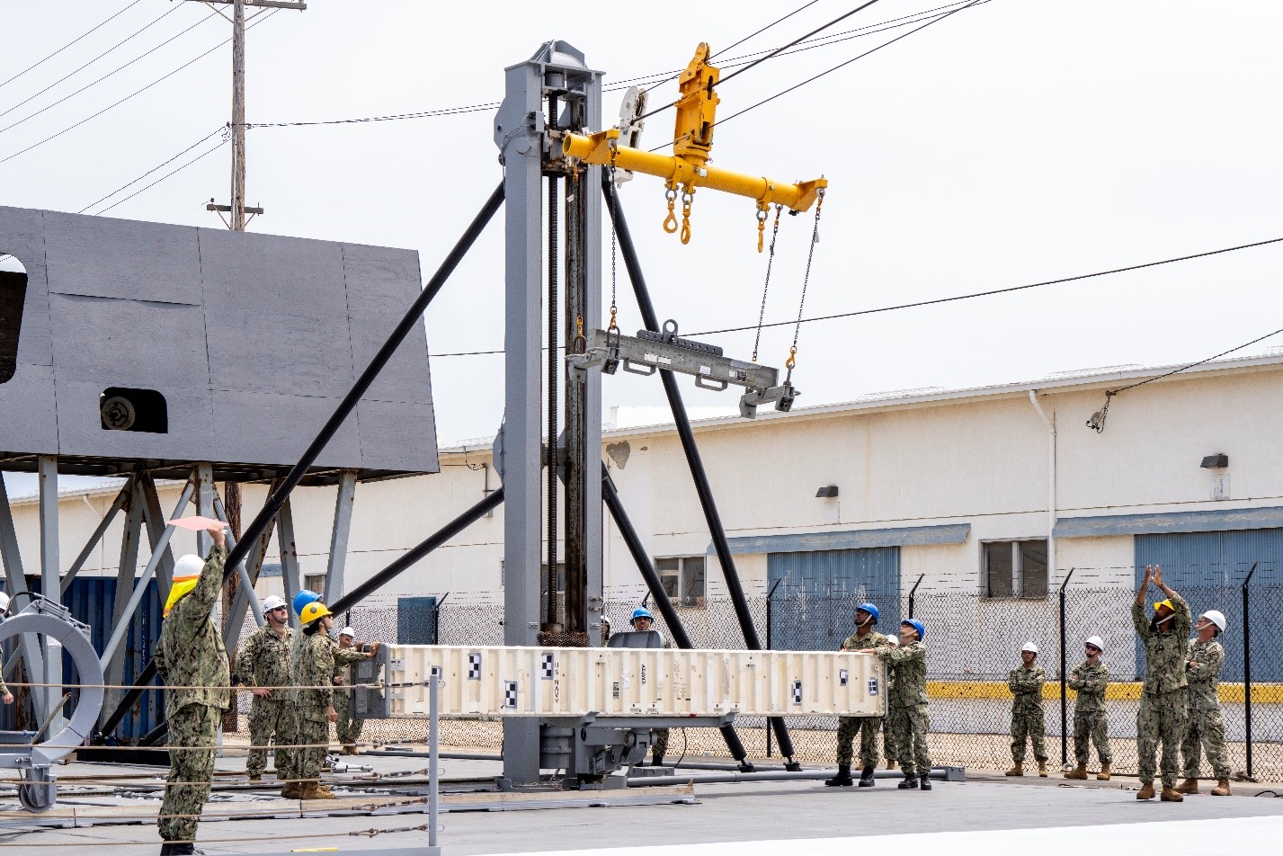 Sailors from the Navy Expeditionary Logistics Support Group and USS Chosin (CG 65) carefully guide a missile canister during a demonstration of the U.S. Navy’s Transferrable Rearming Mechanism on July 10 at Naval Surface Warfare Center, Port Hueneme Division’s Underway Replenishment Test Site. (Photo courtesy of Craig Weiman, Johns Hopkins University/Applied Physics Laboratory)