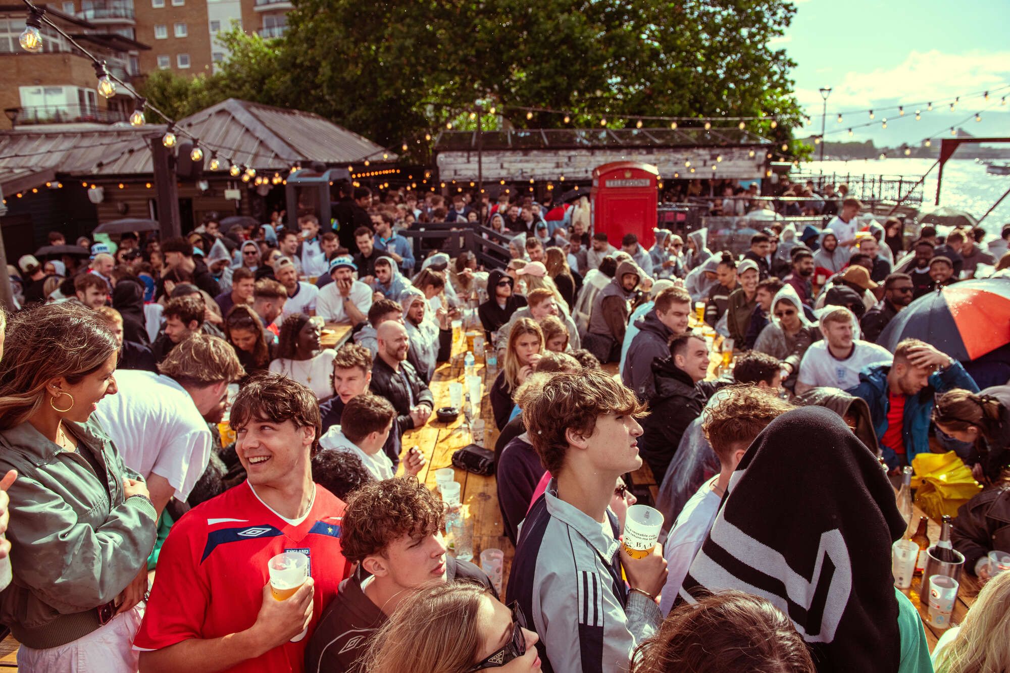 People enjoy an outdoor space on the Thames at a pub